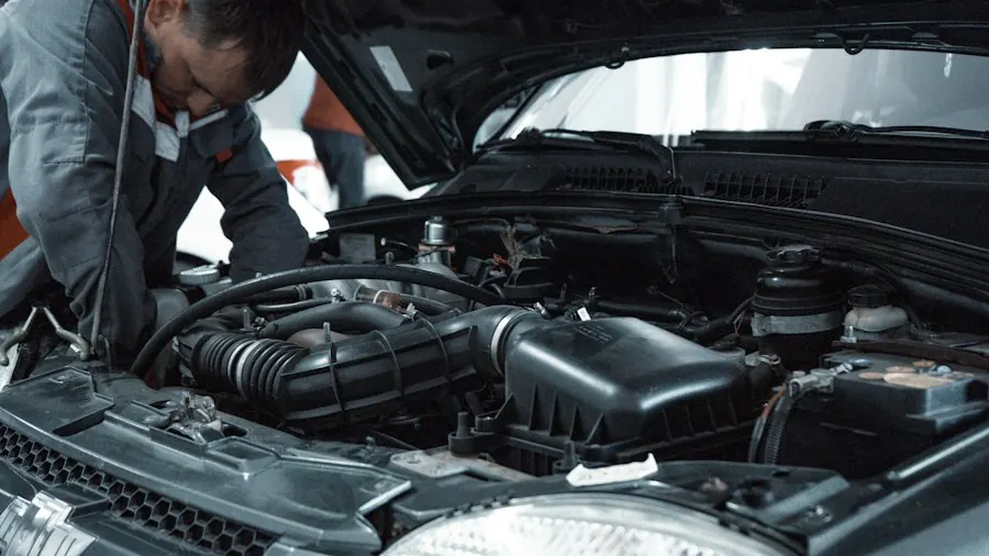 Mechanic in uniform inspecting a car engine