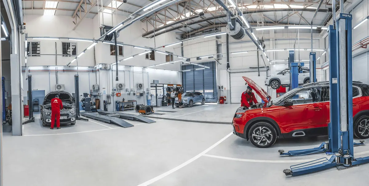 Mechanics working on cars in a bright repair workshop