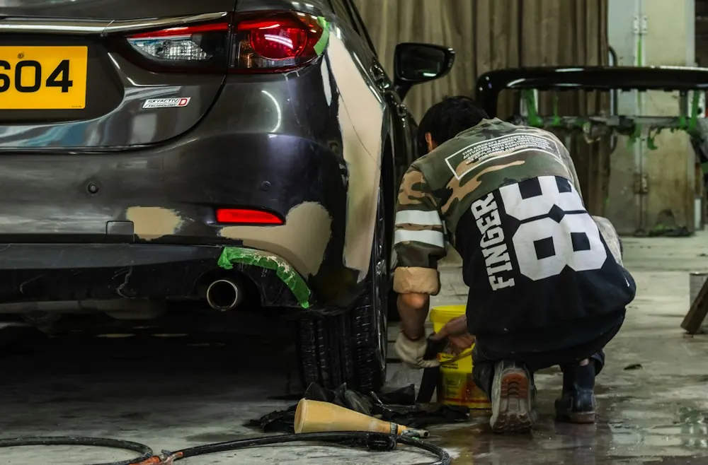 Technician repairing a car bumper in a workshop