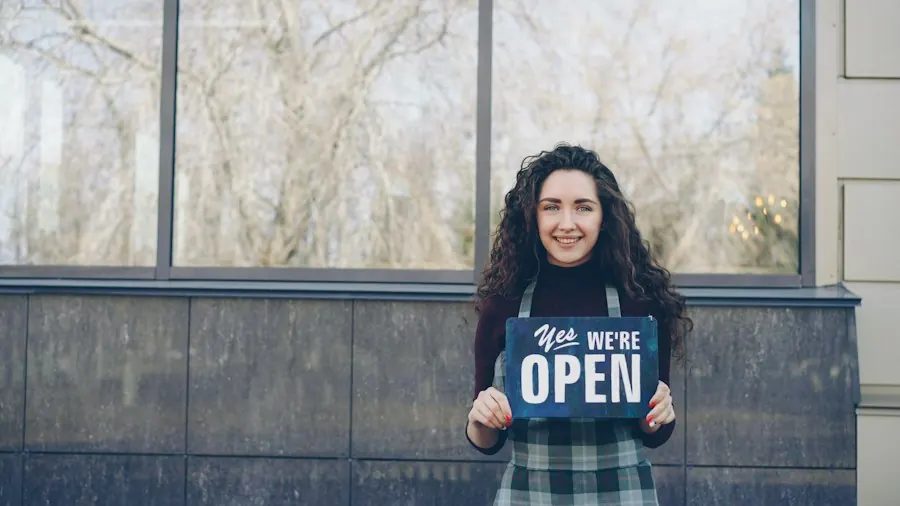 Smiling business owner holding an open sign