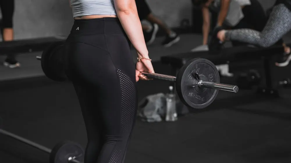 Woman lifting a barbell in a gym