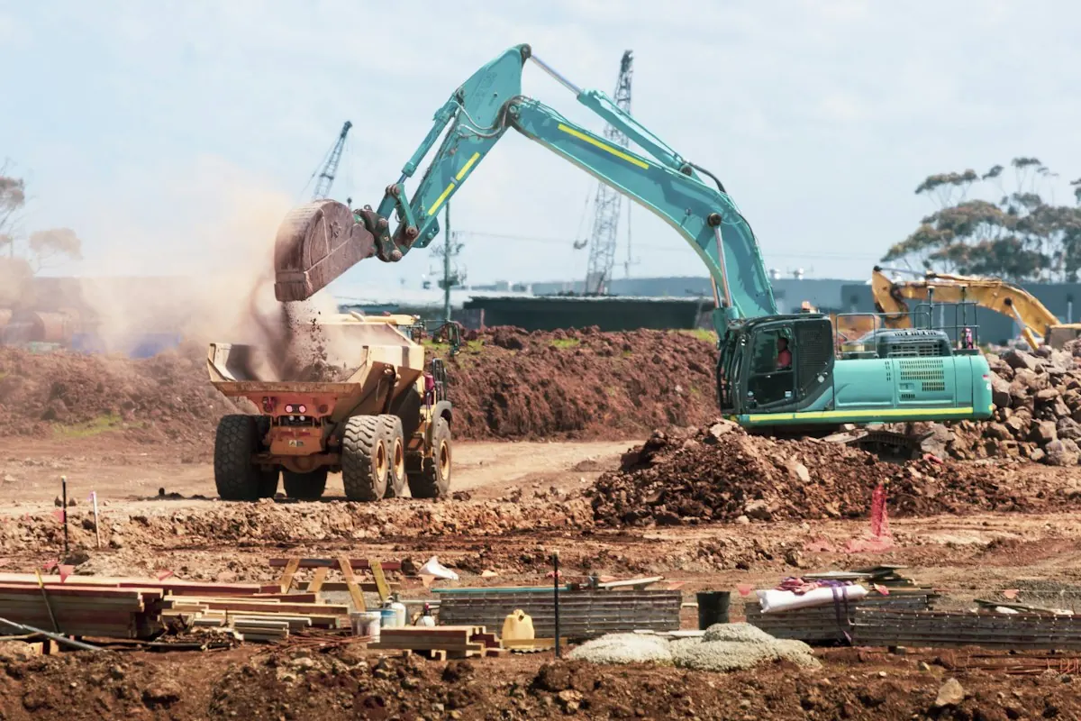 Excavator loading soil into a dump truck at a construction site