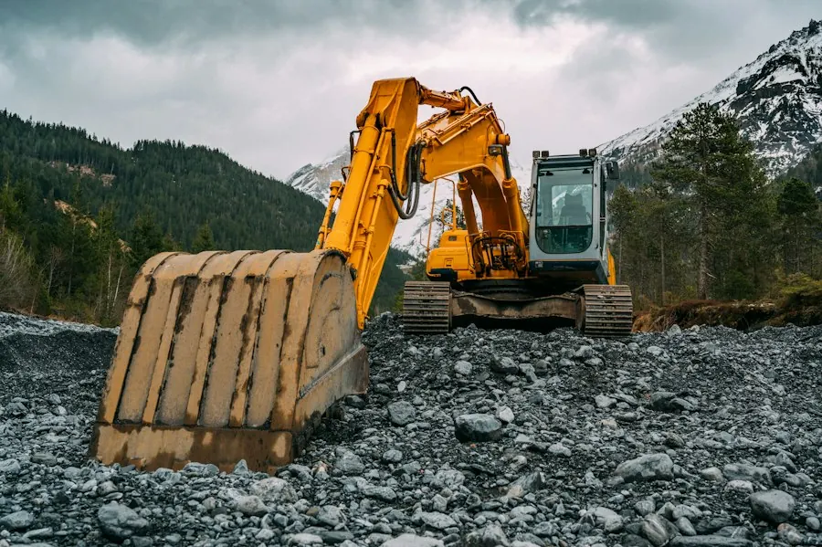 Yellow and black excavator working on rocky ground