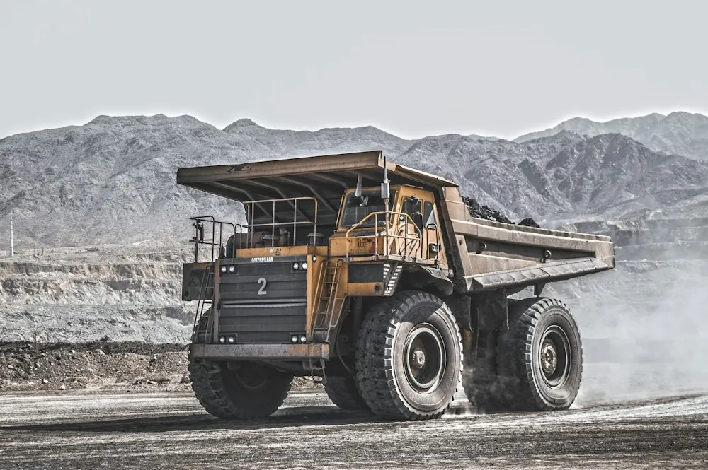 Yellow haul truck on a dusty mine road