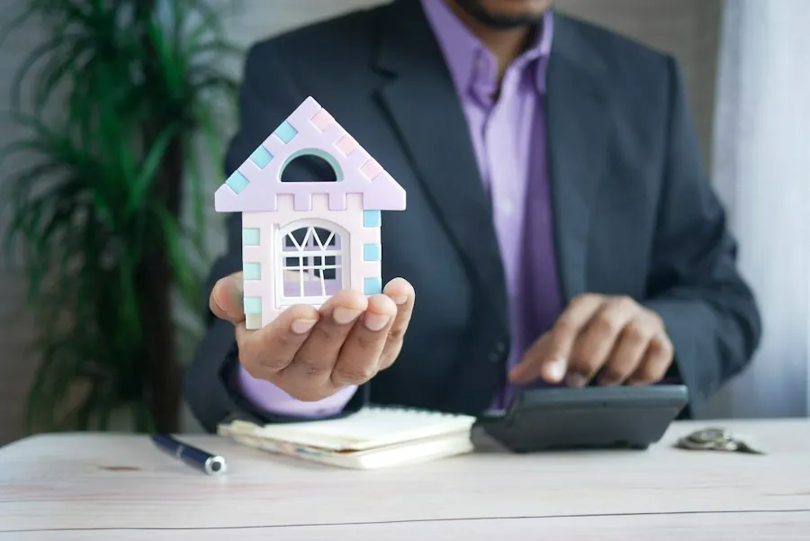 Agent holding a small house model