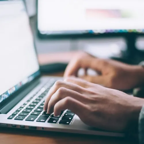 Writer typing on a laptop