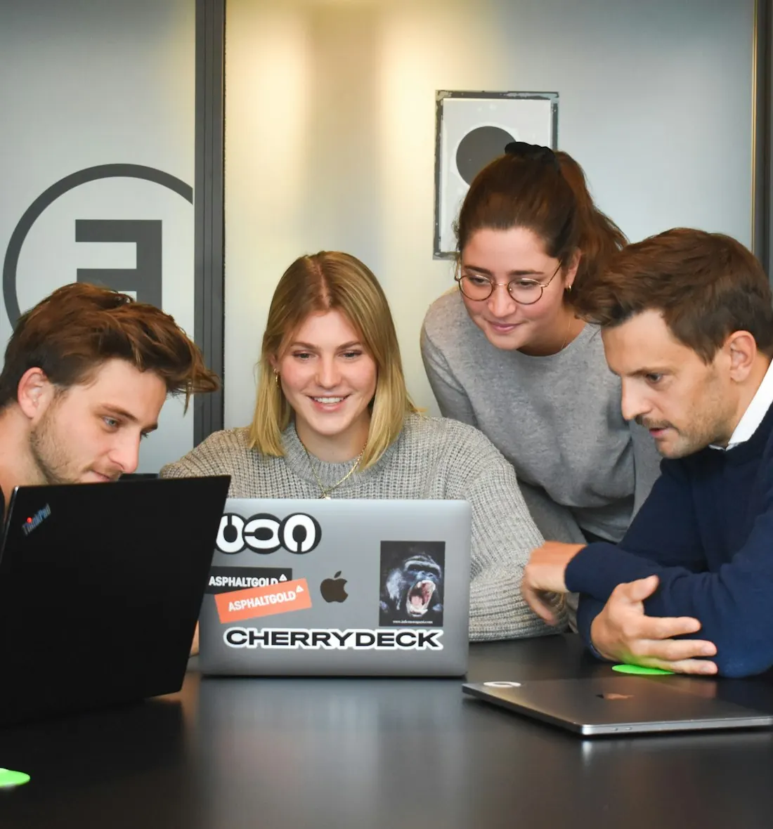 Agency team collaborating around a laptop